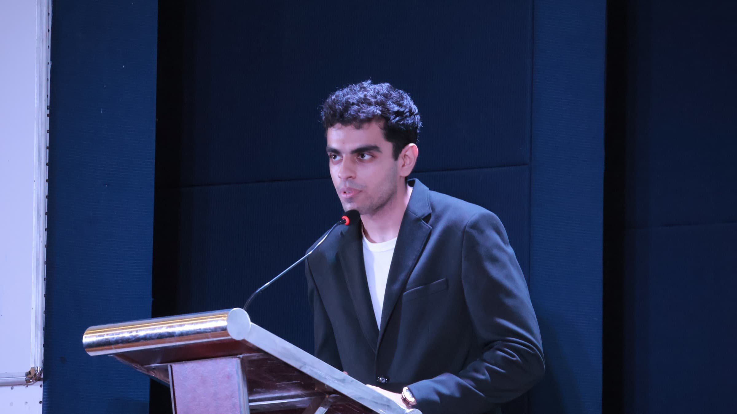 Tanay speaking at a podium